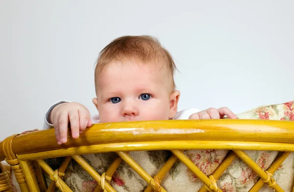 Jongen is kijken via een top van stoel — Stockfoto