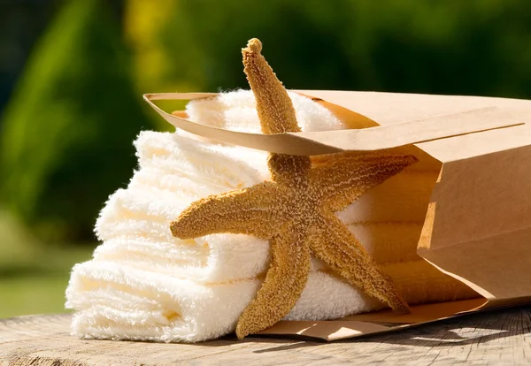 Asciugamani con sacchetto di carta e stella marina — Foto Stock