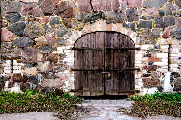 Porta de madeira em uma parede de pedra — Fotografia de Stock