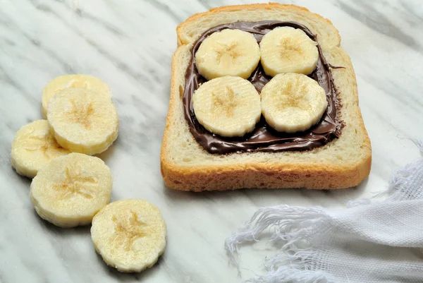 Bread with chocolate cream and sliced banana — Stock Photo, Image