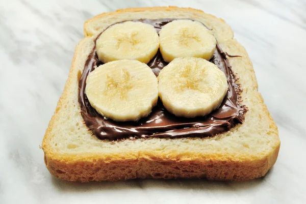 Bread with chocolate cream and slices of banana — Stock Photo, Image