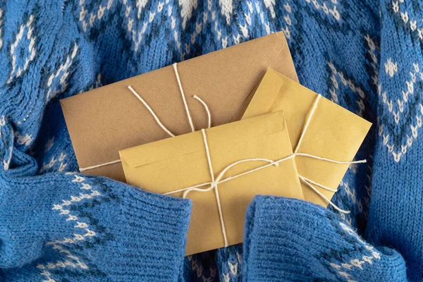 Різдвяний конверт знущається над синім светром. Ніхто не лежав . — стокове фото