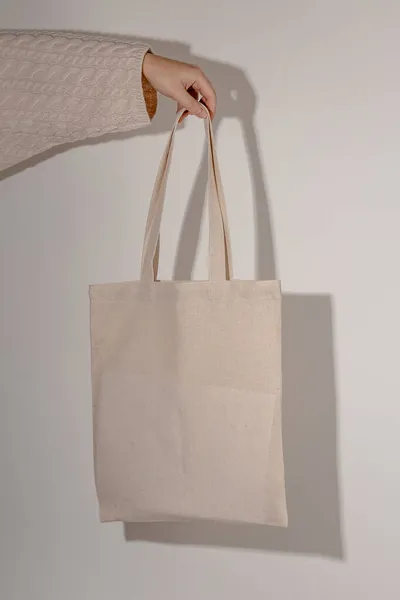 Tote bag mock up in hand of woman in sweater. Eco bag mockup