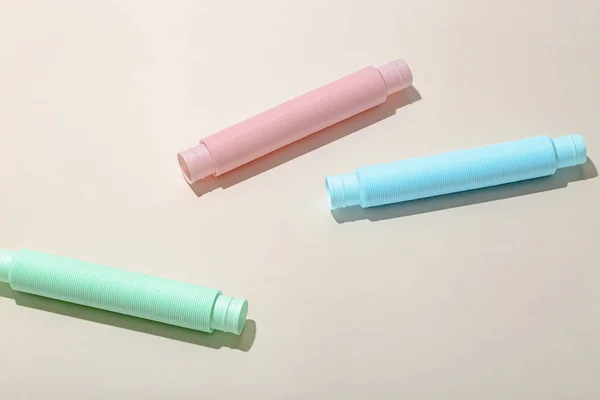 Blauwe munt en paarse anti-stress pop tube speelgoed op een lichte achtergrond. Kinderspeelgoed pastelkleur. Bovenaanzicht. — Stockfoto
