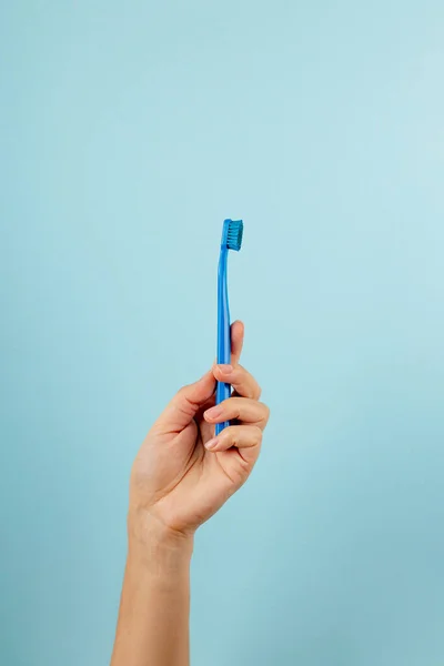 Μπλε μετρητή δοντιών στο γυναικείο χέρι σε γαλάζιο φόντο — Φωτογραφία Αρχείου