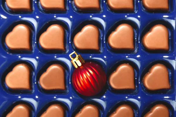 Concepto creativo de Navidad con bola de Navidad en caja de chocolates en forma de corazón. Vista superior. — Foto de Stock