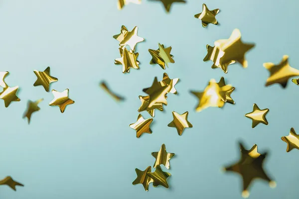 Tło z latającymi złotymi gwiazdami konfetti. Niebieskie tło. Tapeta — Zdjęcie stockowe