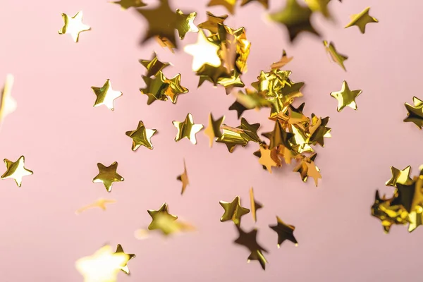 Tło z latającymi złotymi gwiazdami konfetti. Różowe tło. Tapeta. — Zdjęcie stockowe