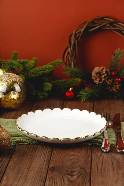 Empty white plate at served Christmas table among decorations. — Stock Photo, Image