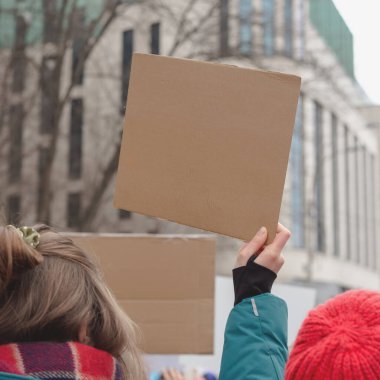 Elinde feminist protestoların arka planına karşı afiş tutan bir kadın. Boşluğu kopyala.