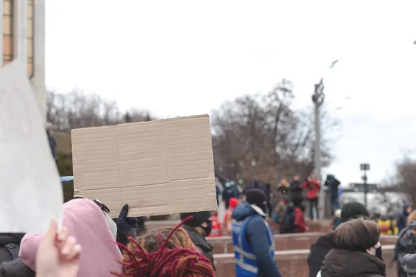 Mulher segurando cartaz na mão contra o pano de fundo do protesto feminista. Espaço de cópia. — Fotografia de Stock