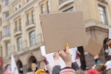 Elinde feminist protestoların arka planına karşı afiş tutan bir kadın. Boşluğu kopyala.