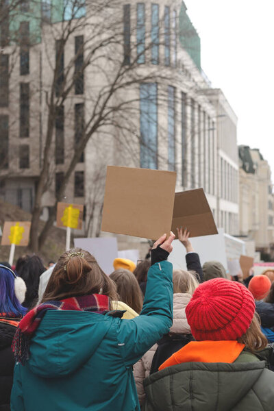 Женщина держит плакат в руке на фоне феминистского протеста. Копирование пространства.