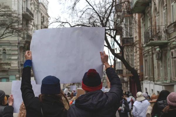 Два человека держат плакат в руках на фоне феминистского протеста. — стоковое фото