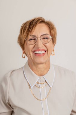 Middle-aged baby boomer woman smiles broadly with beautiful healthy teeth.
