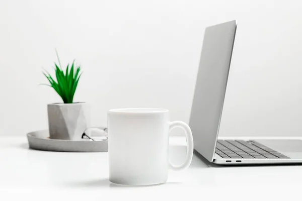 Fehér bögre mockup modern, stílusos munkahelyen laptoppal. Kupa mockup. — Stock Fotó