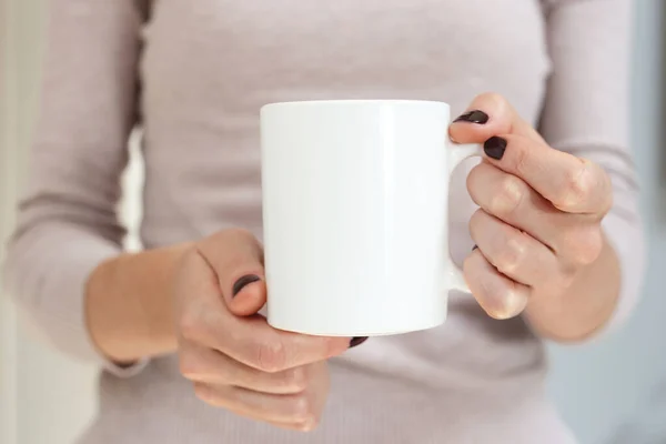 Mockup caneca de café branco para demonstração de design. Xícara elegante simular na mão feminina. — Fotografia de Stock