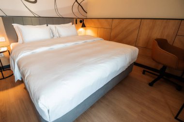 Birinci sınıfta dinlenmek için parlak ve rahat bir otel odası.