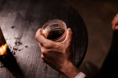 Pahalı bir takım elbisenin içinde elinde bir bardak viski ve kan olan bir adam. Alkolizm ve Aile İçi Şiddet