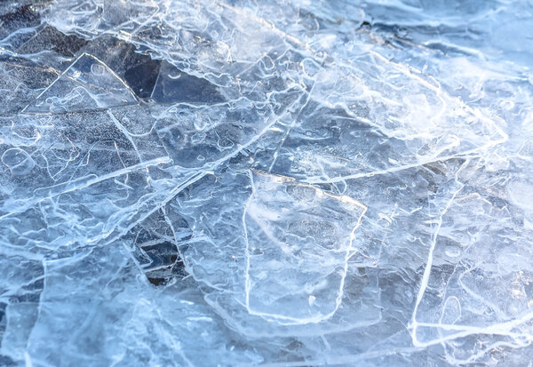 Natural cracked ice texture on river in spring