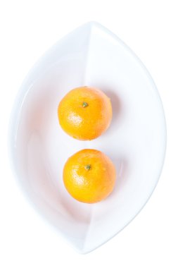 Beyaz bir arka plan üzerinde izole beyaz tabakta iki mandalina