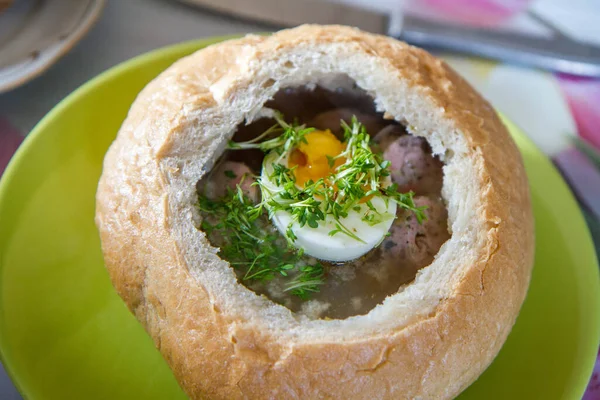 Sour barley soup served in hollowed bread with egg, watercress