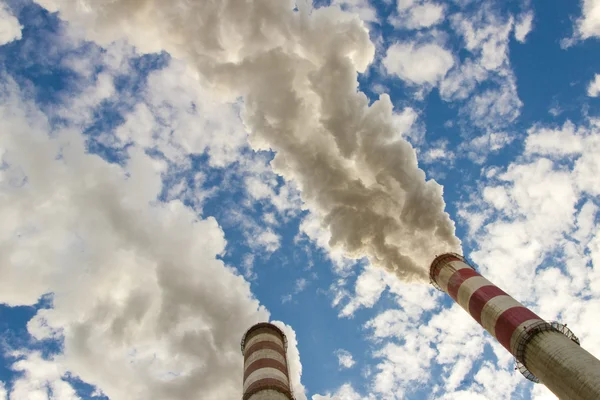 Dos chimeneas, humo y cielo azul . — Foto de Stock