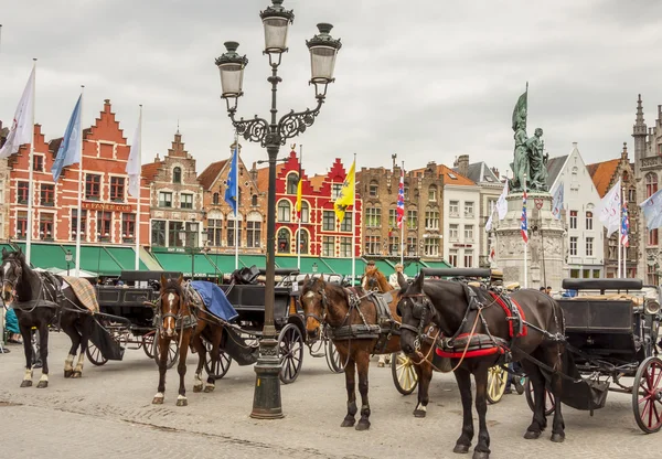 BRUGGE, BELGIUM - APRIL 22:Horses and carriages in the market pl — Stock Photo, Image