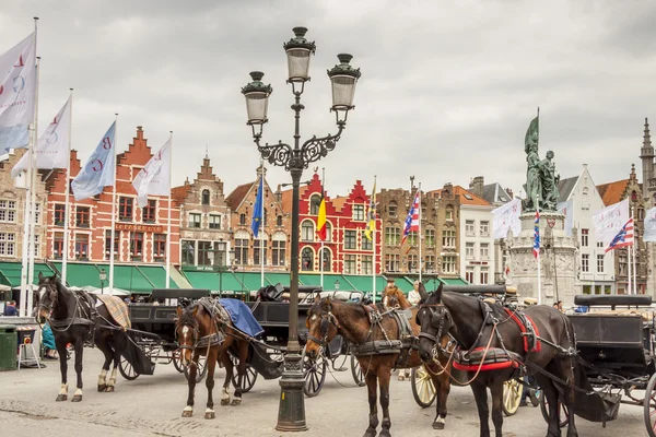 BRUGGE, BÉLGICA - ABRIL 22: Cavalos e carruagens no mercado pl — Fotografia de Stock