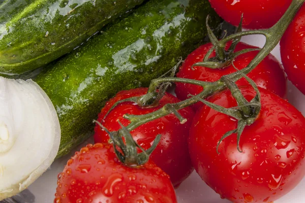 Pepinos, cebola e tomate vermelho na placa branca . — Fotografia de Stock