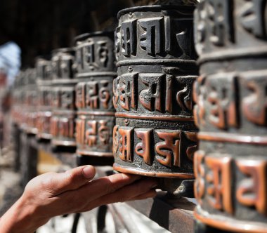 many prayer wheels and hand