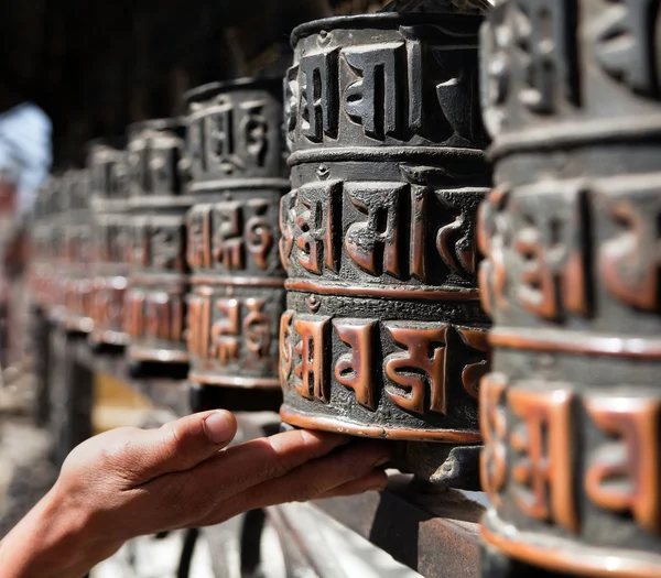 Many prayer wheels and hand — Stock Photo, Image