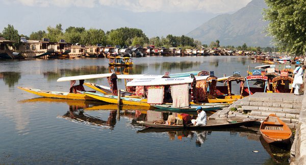 KASHMIR, INDIA - AUG 3 Shikara boats on Dal Lake with houseboats in Srinagar - Shikara is a small boat used for transportation in the Dal lake - 3rd of August 2013, Srinagar, Jammu and Kashmir, India