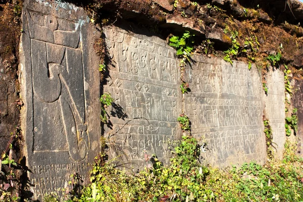 Mani wall and stones with buddhist symbols — Stock Photo, Image