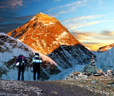Kala Patthar 'dan Everest Dağı' nın akşam renkli görüntüsü. Everest ana kampı, Sagarmatha ulusal parkı, Khumbu vadisi, Solukhumbu, Nepal Himalayaları 'na giden iki turist ile birlikte.