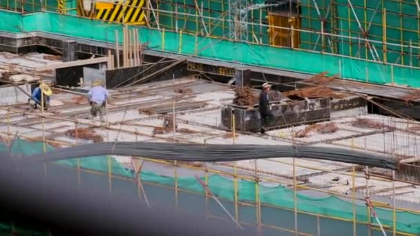 Trabajadores de la construcción en la azotea de un edificio residencial en construcción — Vídeo de stock