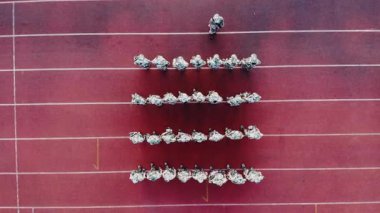 Askerlerden oluşan birlikler yeşil alanda duruyorlar..