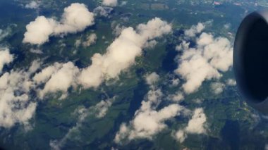 Beyaz bulutlu ve uçak motorlu dağ aralığının görüntüsü.