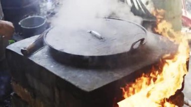 Demir tencerede geleneksel Çin çorbası yapmak, eski sobanın yanında odun ateşiyle ısıtmak.