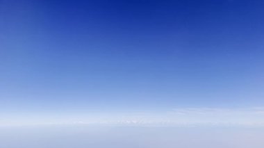 Everest dağ sırtı, bulutların üzerinden geçen uçağın arka plan görüntüsünde mavi bir gökyüzü. Yüksek kalite 4k görüntü