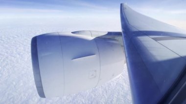 Beyaz bulutların görüntüsü ve bulutların üzerinde uçağın türbini olan bir kanat. Geniş açı. Yüksek kalite 4k görüntü