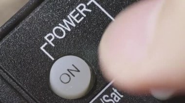 Kafkas erkek eli televizyonun uzaktan kumandasını tutuyor ve akıllı televizyonu açıp kapatıyor. Televizyonu açıp evde dinlenme kavramı. Süper makro yüksek kalite 4K görüntü.