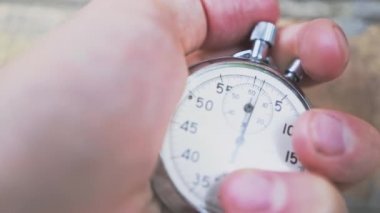 Beyaz erkek eli klasik bir çelik analog kronog kronometre adam çalıştırıcısının kronometre tuşuna basıyor. Yanlamasına hareket eden dolly yüksek kalite slayt 4k görüntü 