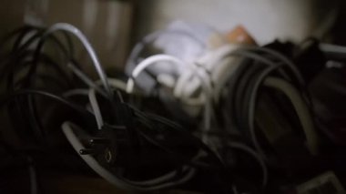 Concept of looking for something in a pile of old wires in the garage with a flashlight. Blackout actions. High quality 4K dolly footage.