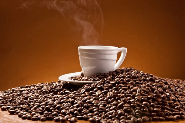 Cup of coffee and coffee beans on the background of Terracotta — Stock Photo, Image