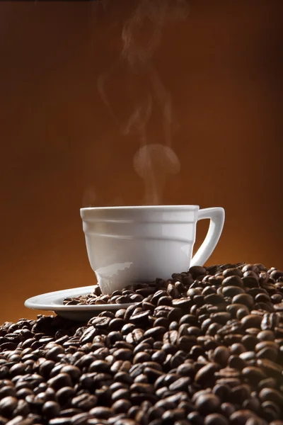 Чашка кави та кавових зерен на тлі теракотовий — стокове фото