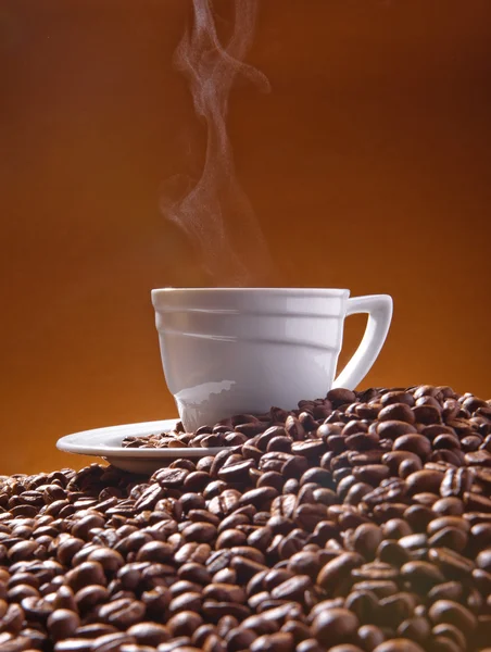 Cup of coffee and coffee beans on the background of Terracotta — Stock Photo, Image