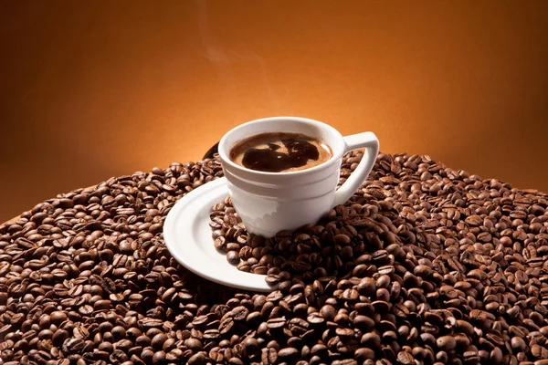 Cup of coffee and coffee beans on the background of Terracotta — Stock Photo, Image