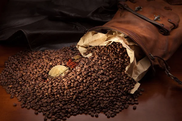 Spilled coffee beans and African medallion with eagle — Stock Photo, Image