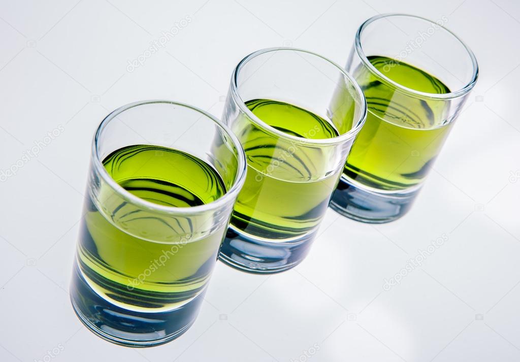 Three glasses of absinthe on white background